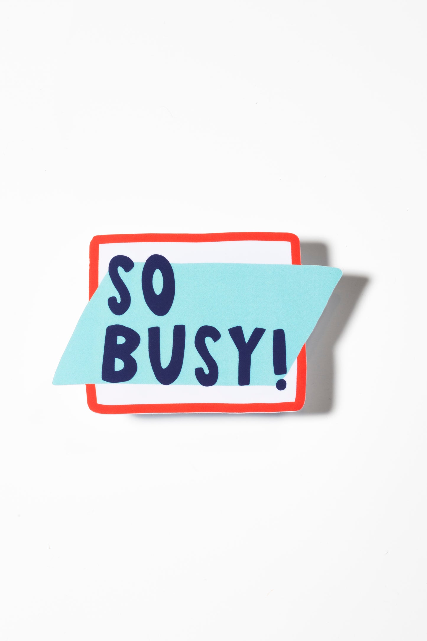 Sticker that says "so busy!" in dark blue all caps with a red border shot on a white background.