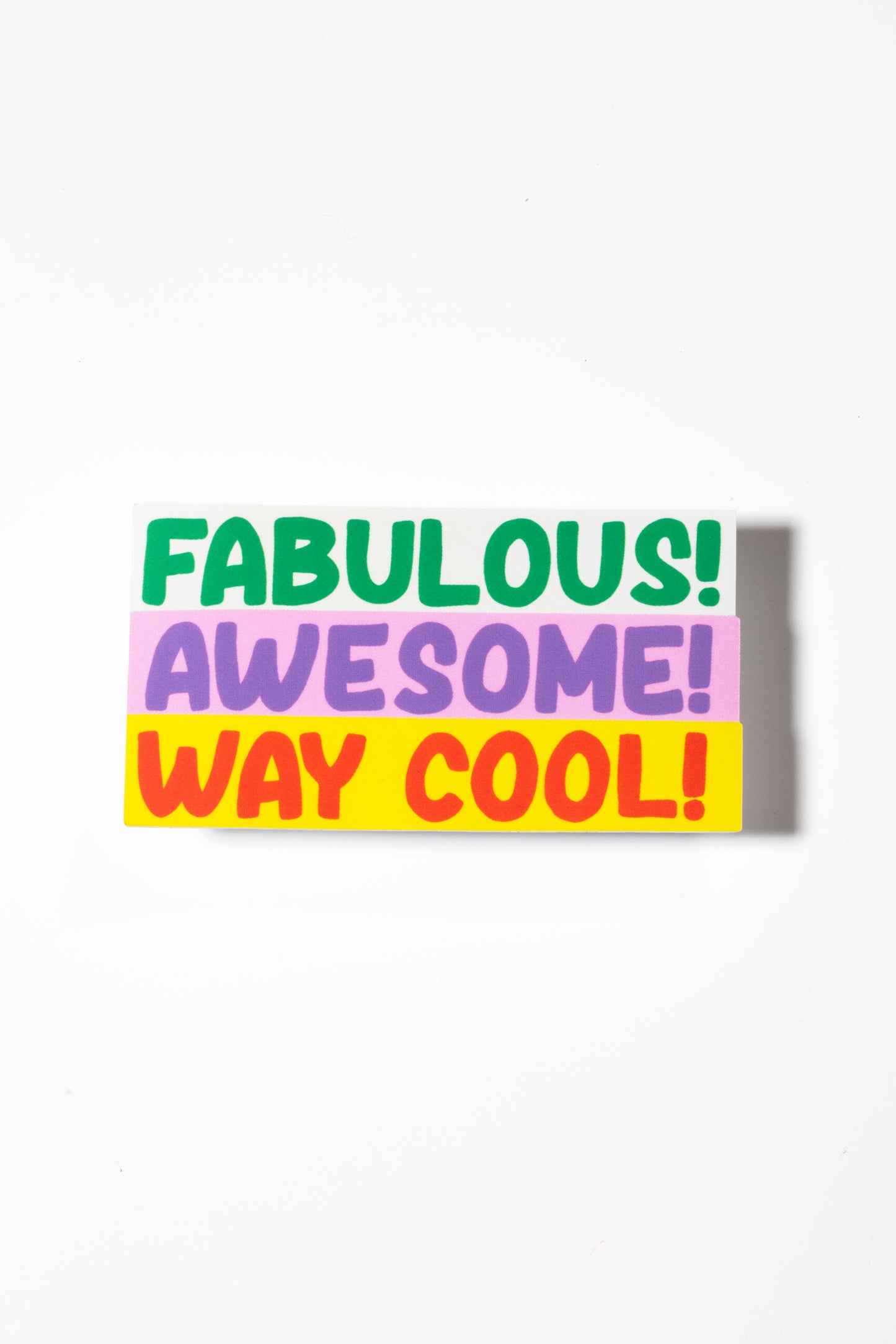 Sticker that reads "fabulous" in green, "awesome" in purple on pink, and "way cool" in red on yellow shot on a white background.