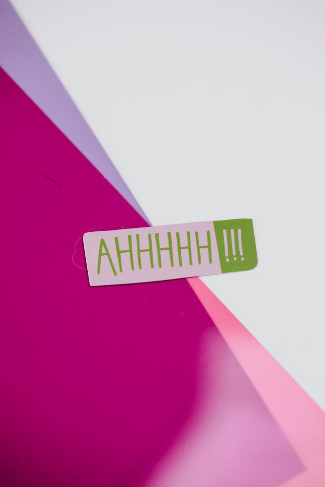 A vibrant sticker displaying the word "ahh" in an eye-catching font, ideal for personalizing belongings with a fun message.