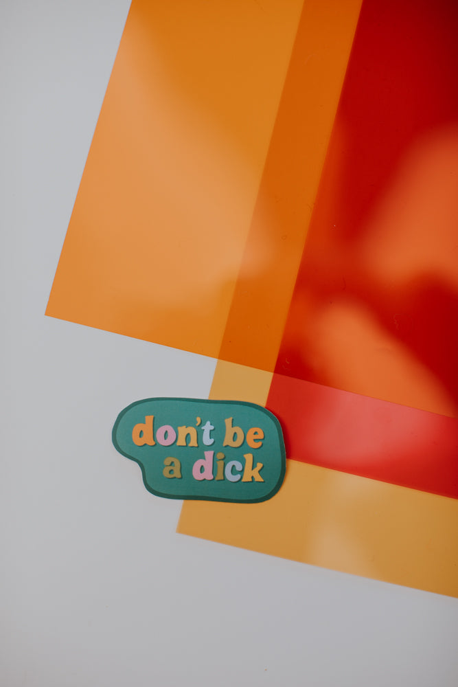 A sage green speech bubble sticker placed on a geometric background with sections of white, orange, and red colors